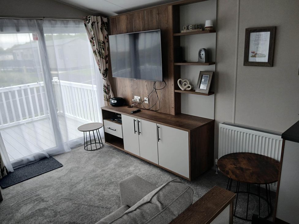A living room with a television and couch at the property near Flookburgh