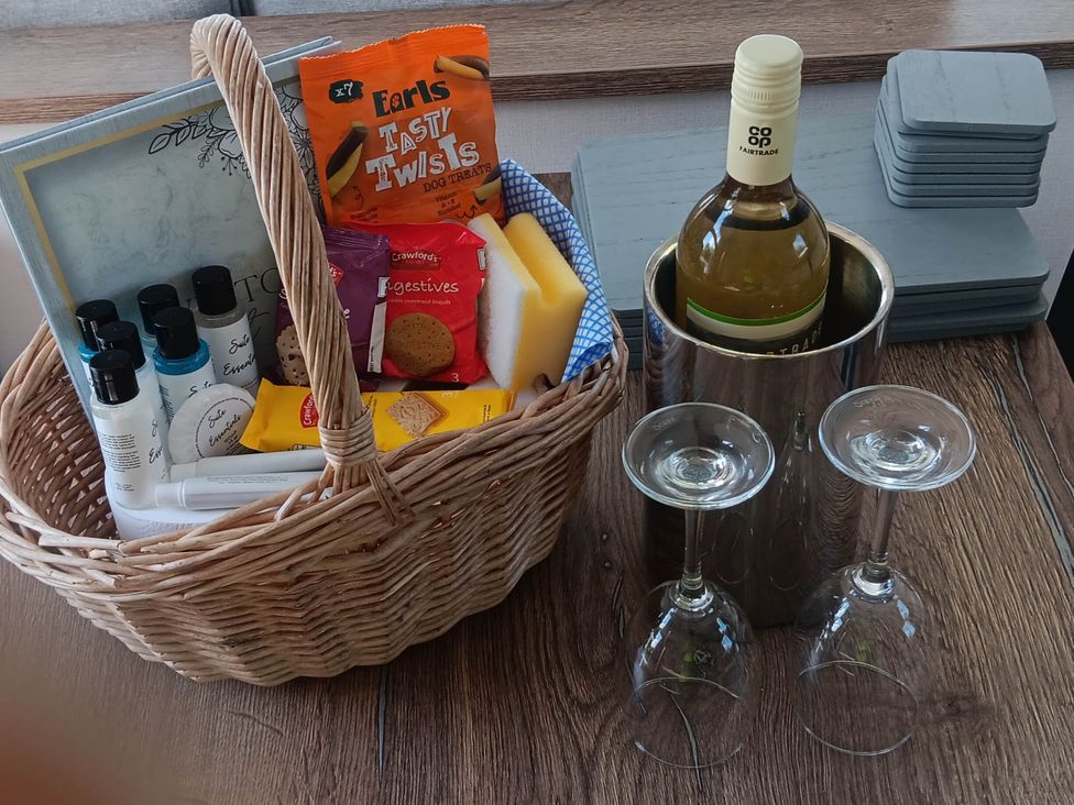 A basket with snacks and a wine bottle at a property near Flookburgh