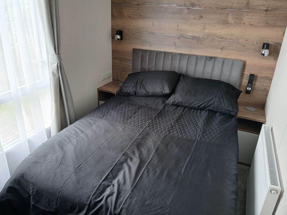 A bedroom with a bed and nightstand at The Old Barn in Near Flookburgh
