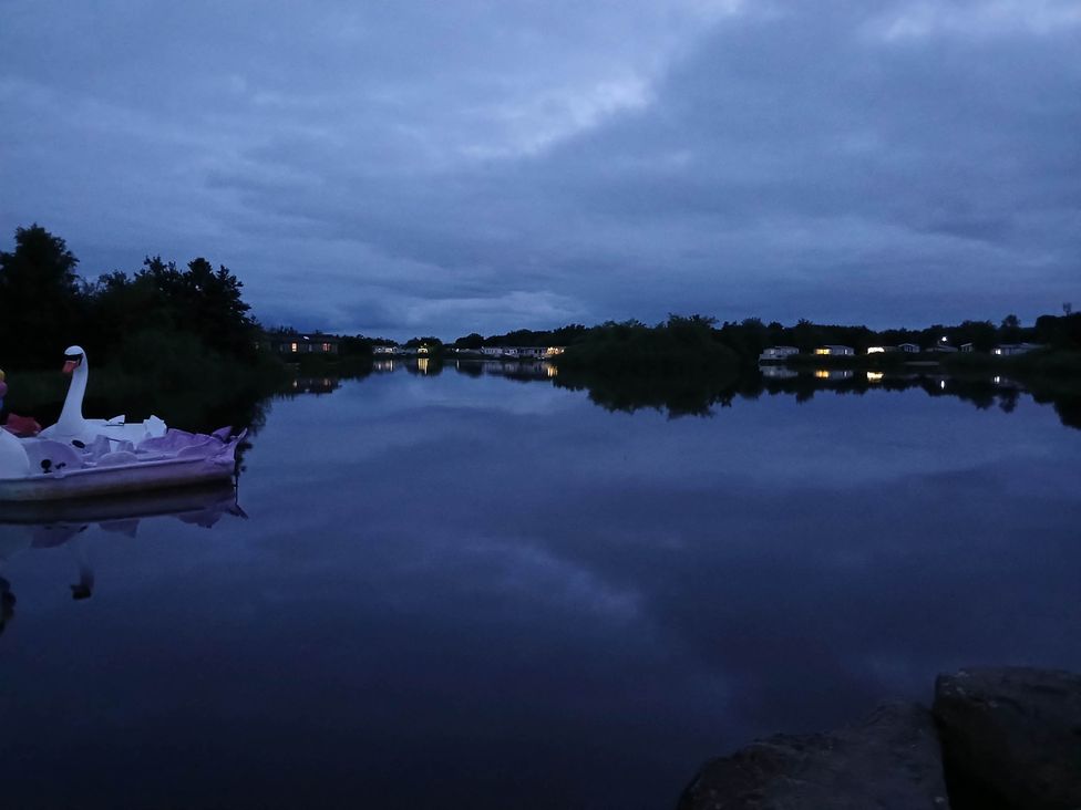 A view of a lake with a swan paddle boat at a location near Flookburgh