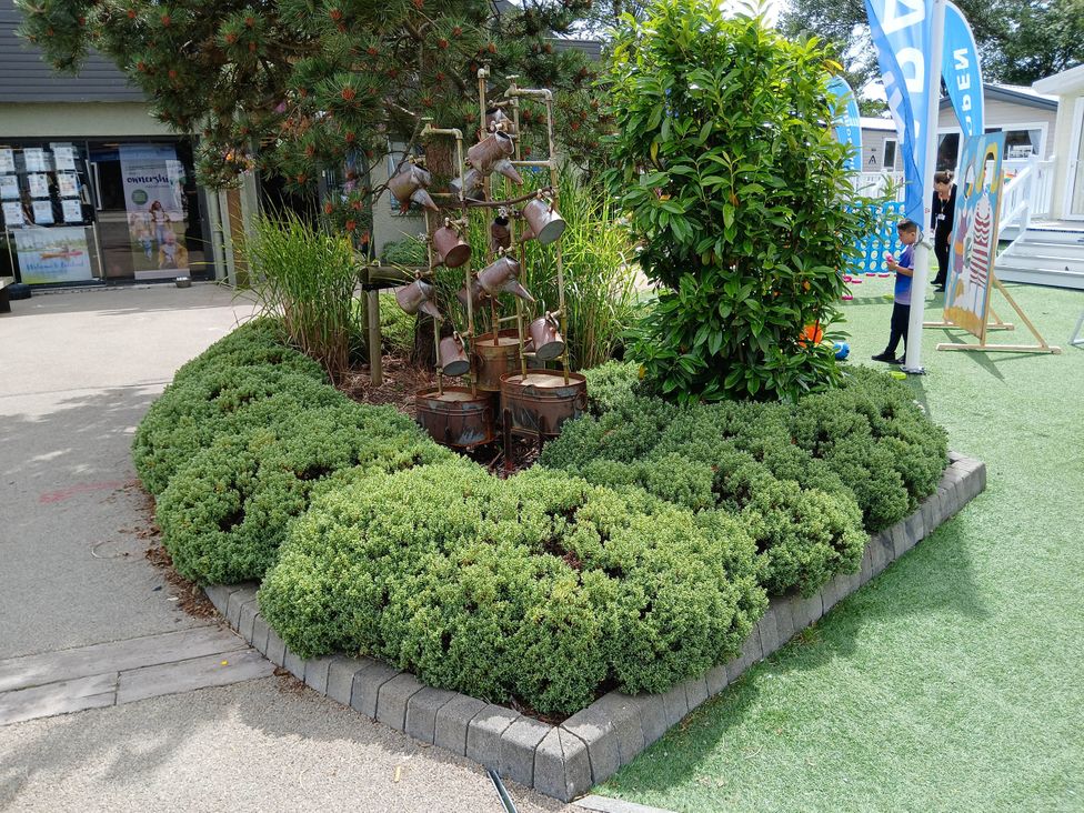 An outdoor area with bushes and a tree at a recreational facility near Flookburgh