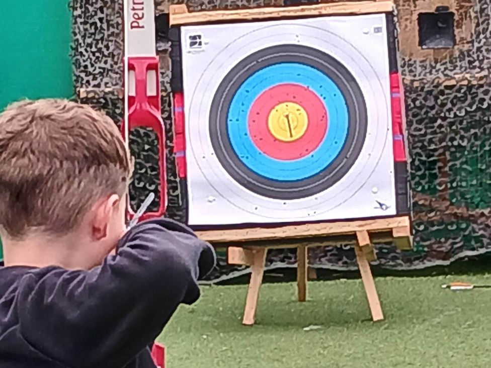 A person aiming at an archery target at an outdoor archery range near Flookburgh