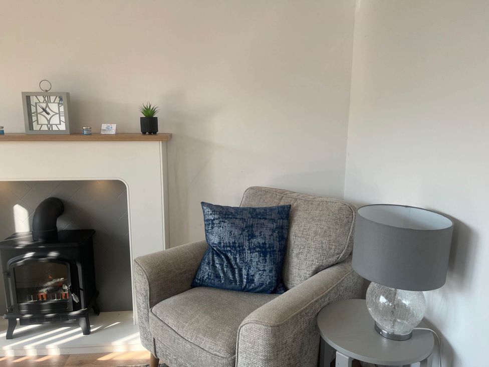 A living room with an armchair and fireplace at The Old Barn in Bridlington