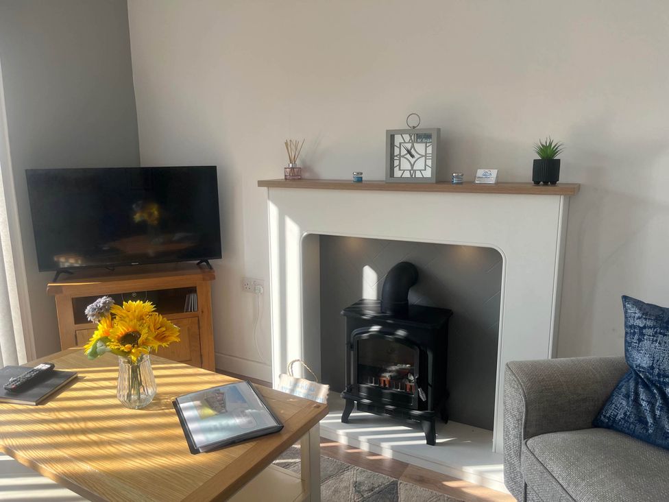 A living room with a television and fireplace at The Old Barn in Bridlington
