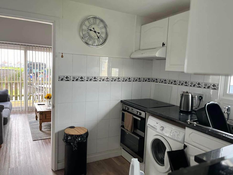 A kitchen with an oven and washing machine at The Old Barn in Bridlington