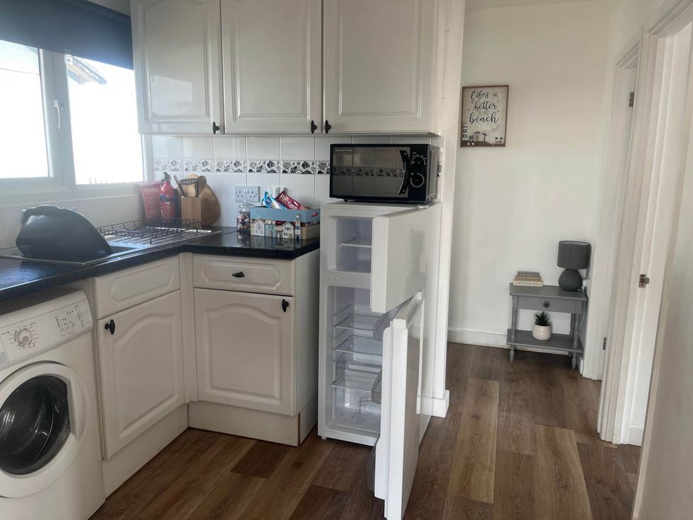 A kitchen with a refrigerator and washing machine at Bridlington