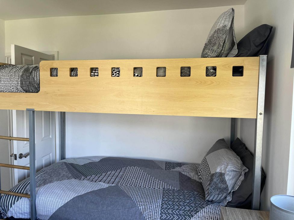 A bunk bed with gray bedding in a bedroom