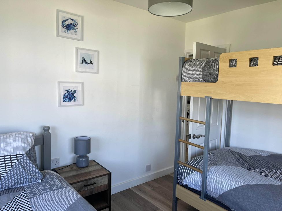 A bedroom with a bunk bed and twin bed at The Old Barn in Bridlington