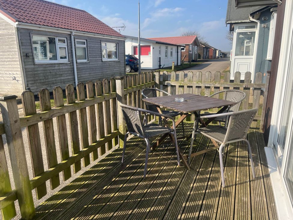 A deck with a table and chairs at a property in Bridlington