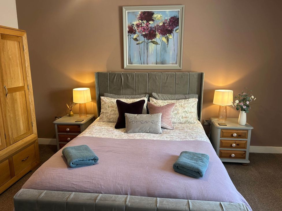 A bedroom with a bed and bedside tables at The Old Barn in Nebo near Penygroes