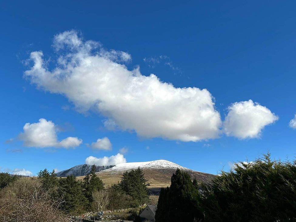 A mountain with snow and clouds at an outdoor location