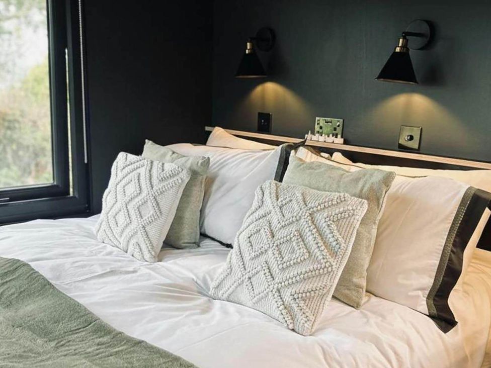 A bedroom with a bed and pillows at The Old Barn in Newton Abbot