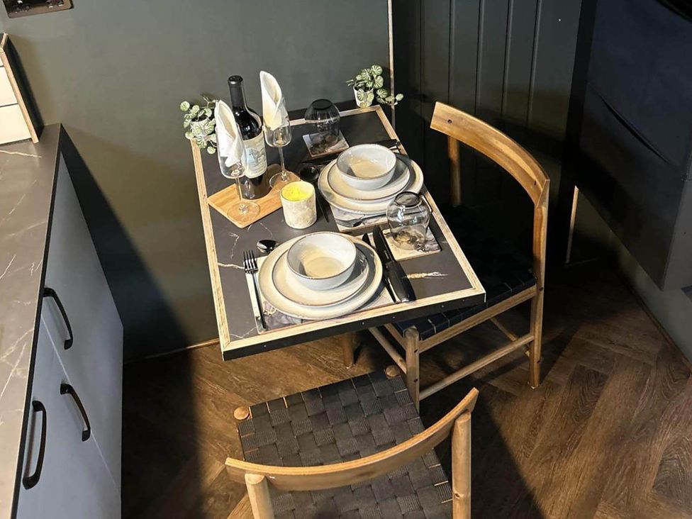 A dining room with a table set for two at The Old Barn in Newton Abbot