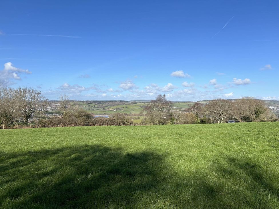 A view of hills and trees under a blue sky at a location in Newton Abbot