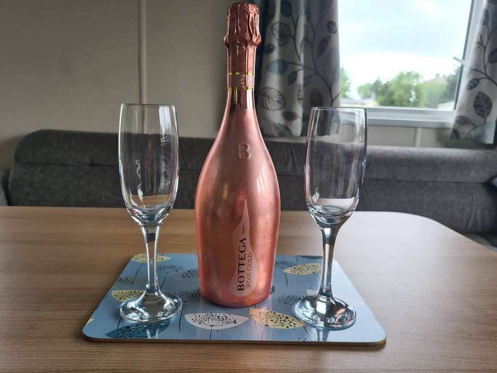 A bottle of champagne and two glasses on a table at The Old Barn in Manchester