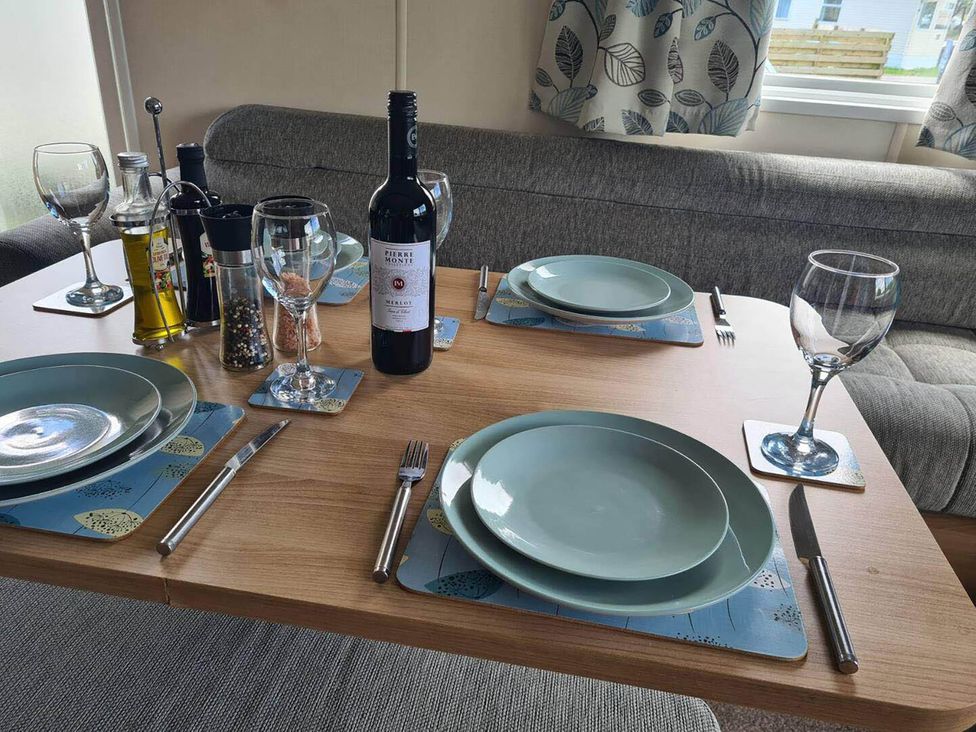 A dining table set with plates and glasses at a property