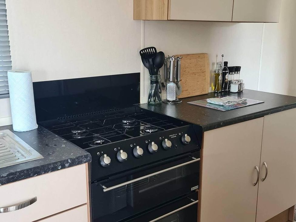 A kitchen with a gas stove and kitchen utensils at a property