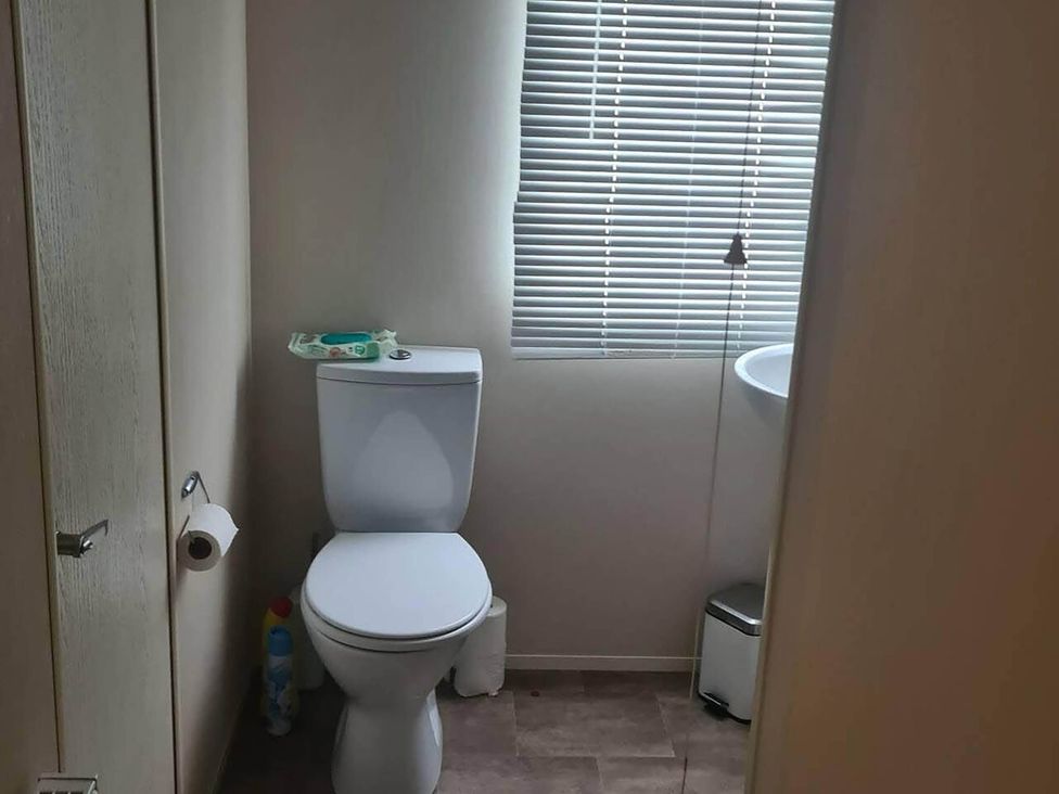 A bathroom with a toilet and window at The Old Barn in Manchester