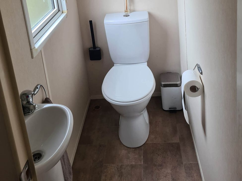 A bathroom with a toilet, sink, and towel at The Old Barn in 