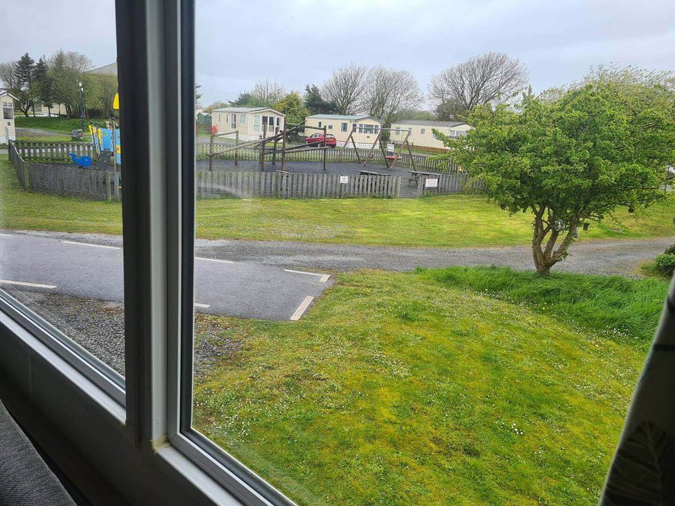 A view from a window showing a playground and holiday homes at a campground