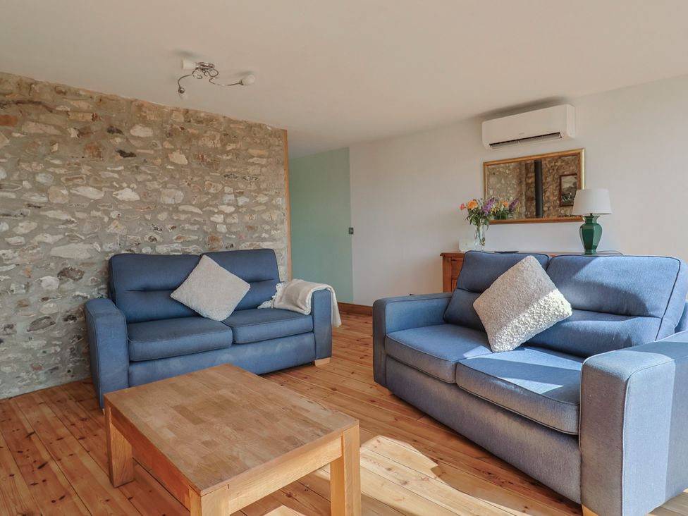 A living room with sofas and a coffee table at The Linhay in Cotleigh Nr. Honiton
