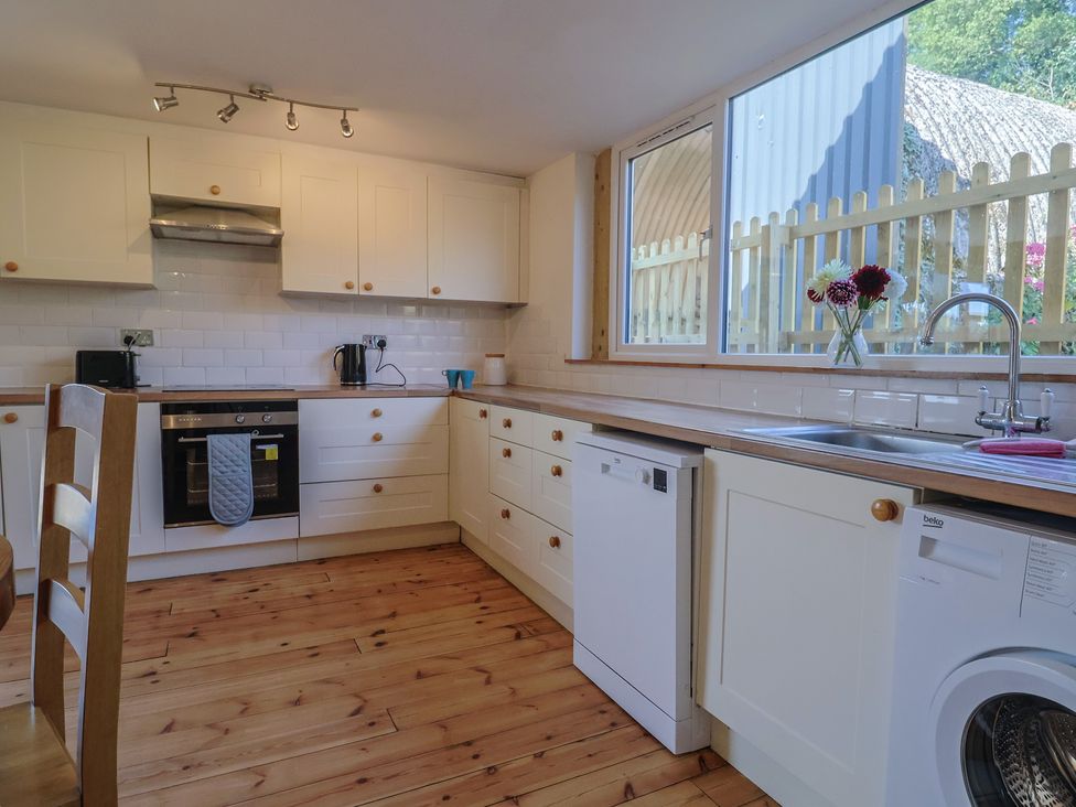 A kitchen with appliances and a window at The Linhay in Cotleigh Nr. Honiton
