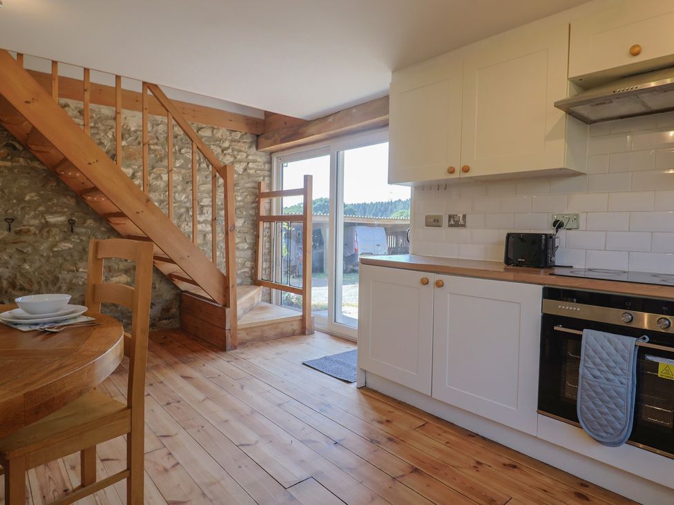 A kitchen with a staircase and dining area at The Linhay Cotleigh Nr. Honiton