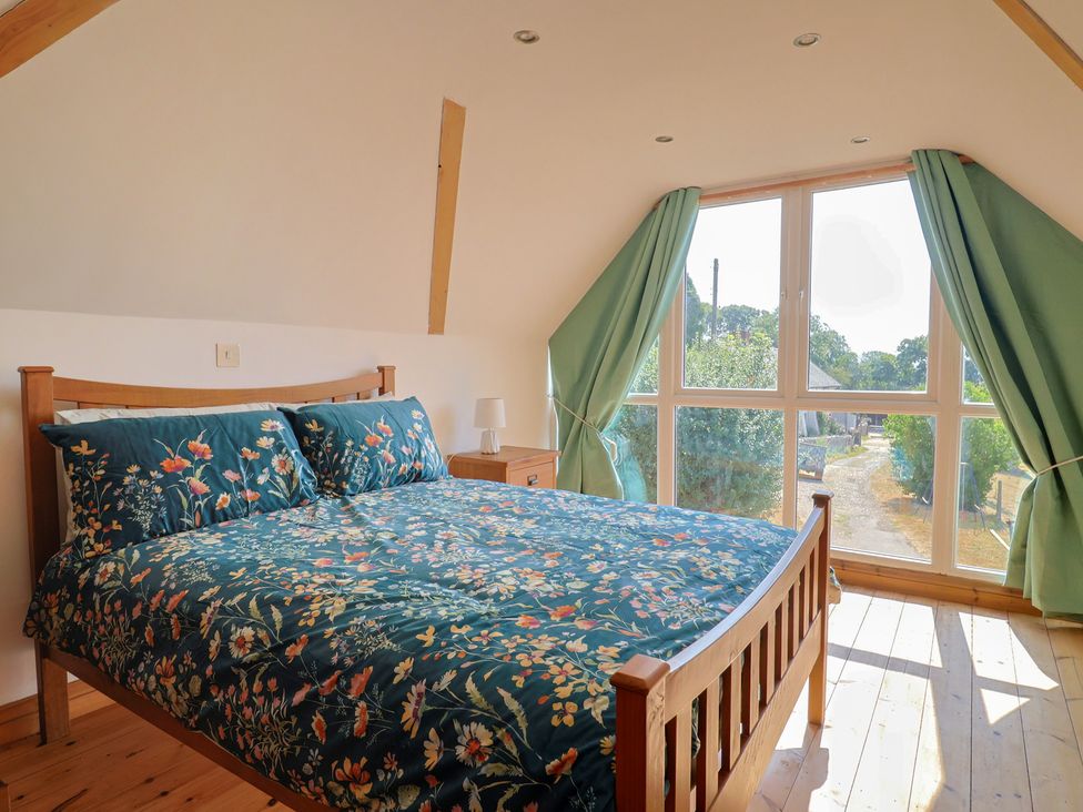 A bedroom with a bed and window at The Linhay Cotleigh Nr. Honiton