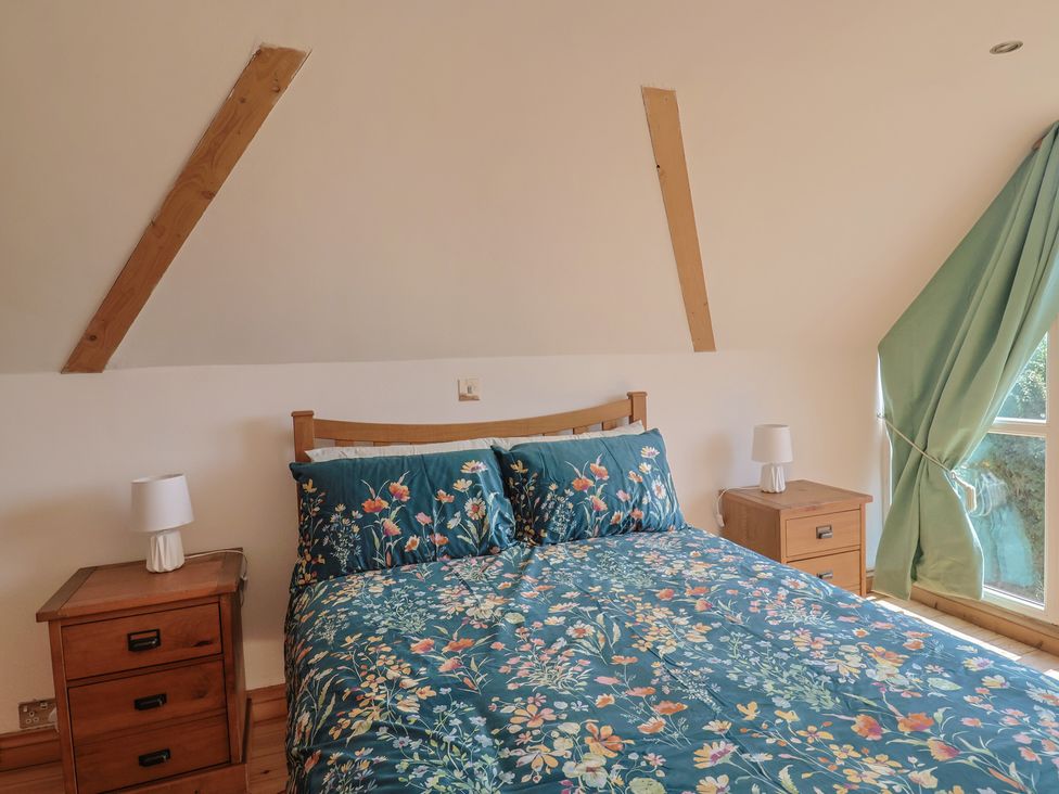A bedroom with a bed and nightstands at The Linhay Cotleigh Nr. Honiton