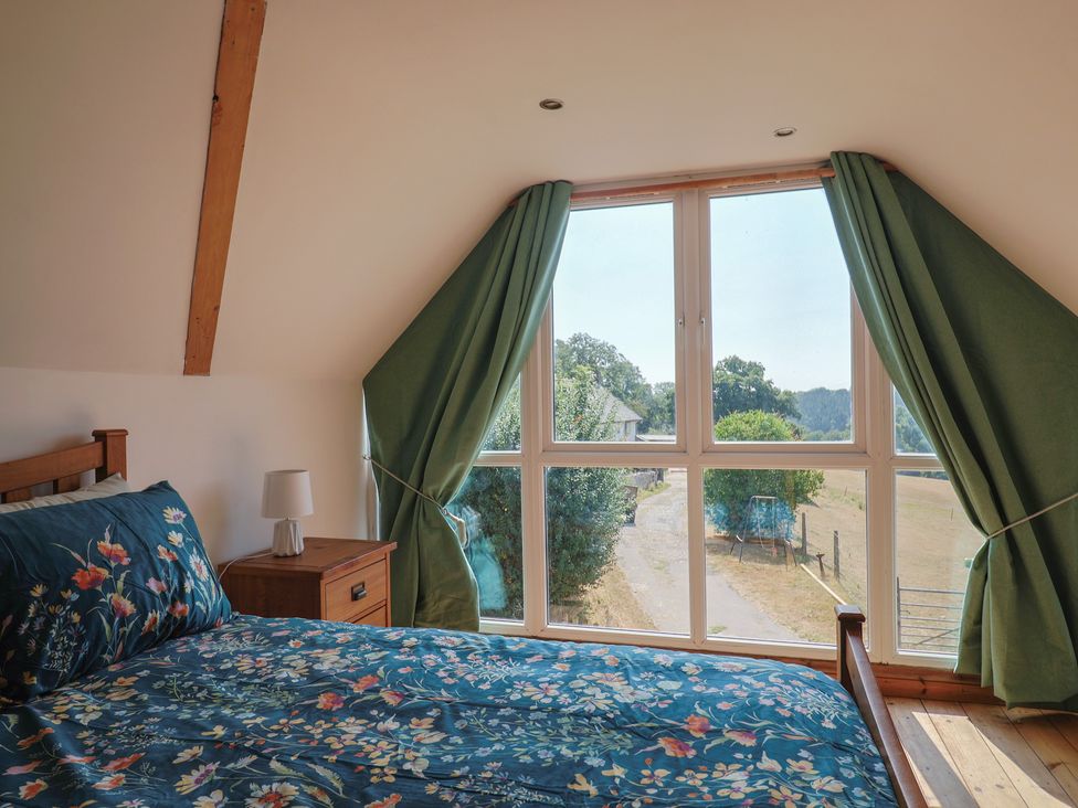 A bedroom with a bed and a window at The Linhay in Cotleigh Nr. Honiton