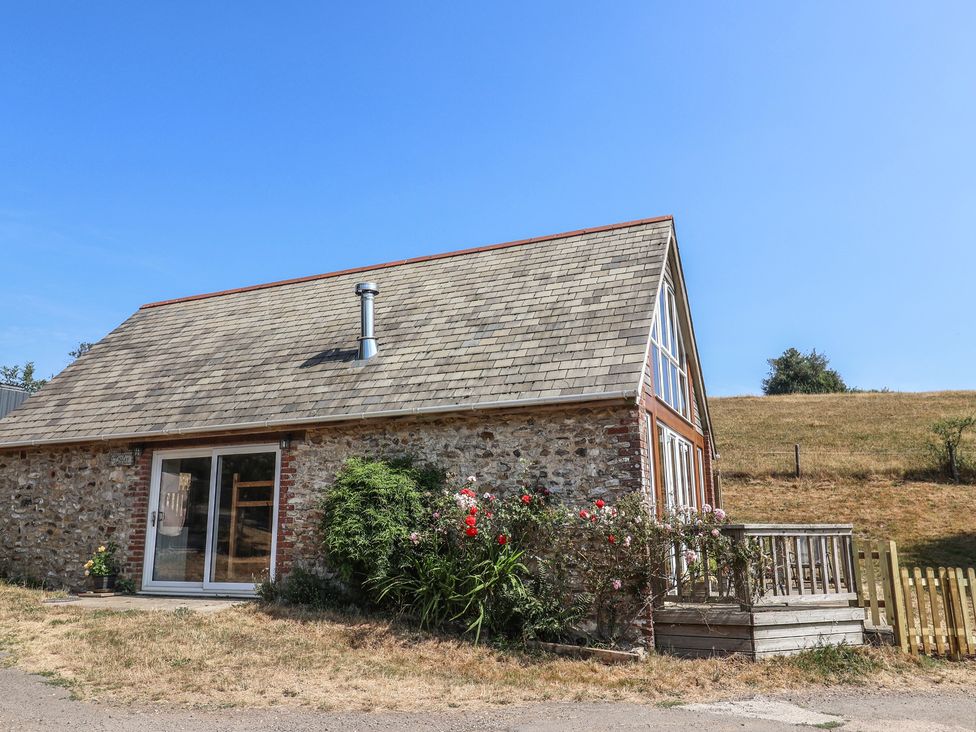 A house with a wooden deck and flowers in front at The Linhay Cotleigh Nr. Honiton