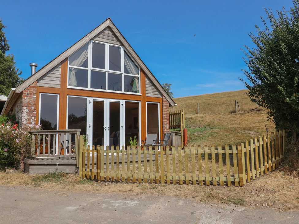 A house with a wooden fence and deck at The Linhay Cotleigh Nr. Honiton