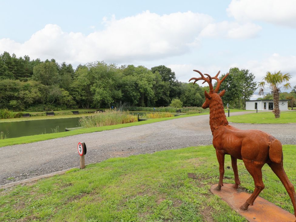 A garden with a deer statue and pond at Goldfinch Pod Swannington near Coalville