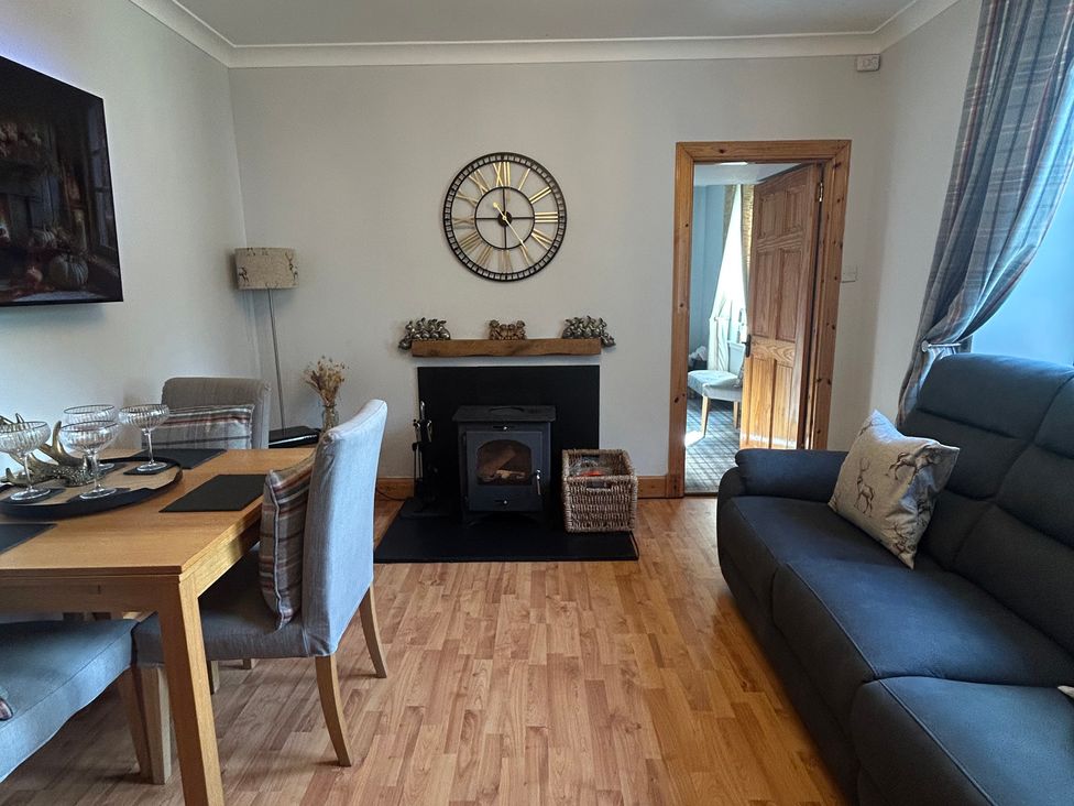 A living room with dining table and sofa at 1 Station Cottages