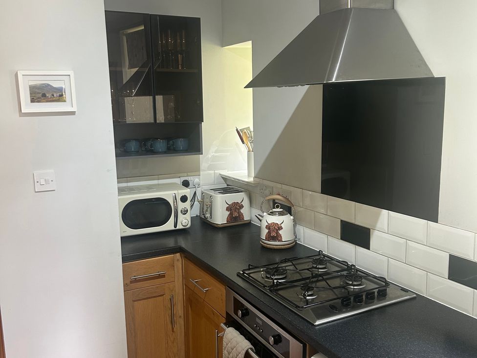 A kitchen with appliances and cabinets at 1 Station Cottages