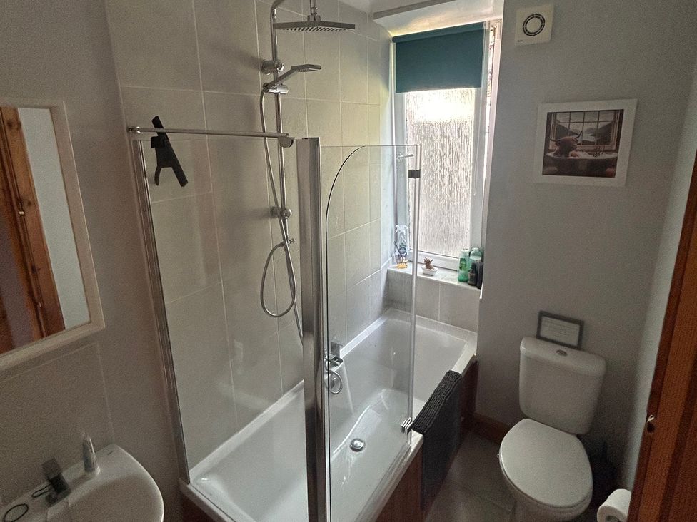 A bathroom with a bathtub and shower at 1 Station Cottages
