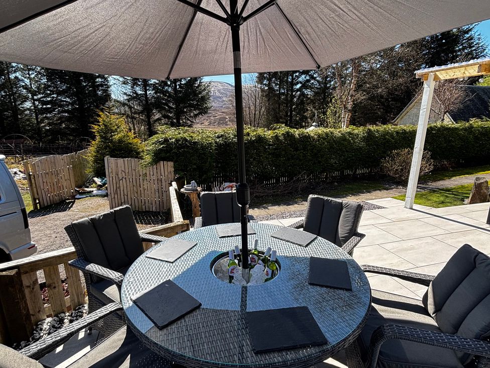 An outdoor dining area with a table and chairs at 1 Station Cottages in 
