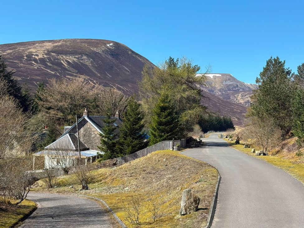 A house on a road with mountains in the background at 1 Station Cottages