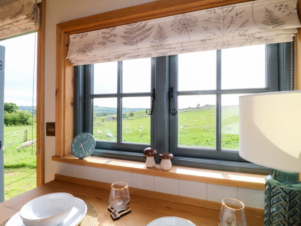 A kitchen with a window showing fields at Pike House Farm Shepherds Hut 2 Thorpe near Ashbourne