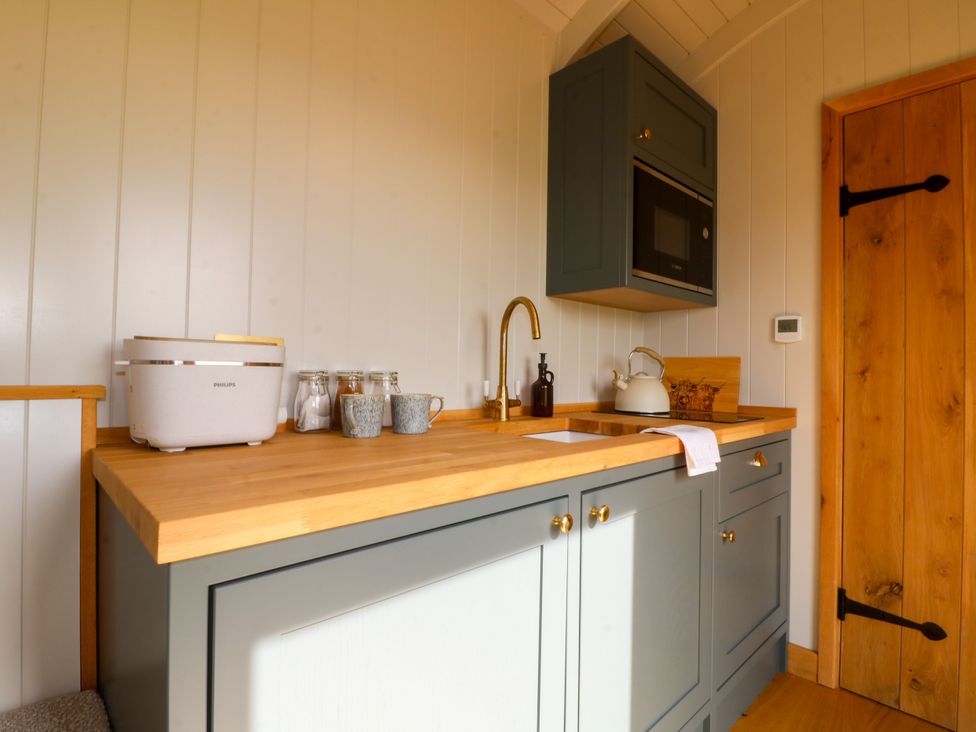 A kitchen with cabinets and a sink at Pike House Farm Shepherds Hut 2 Thorpe near Ashbourne