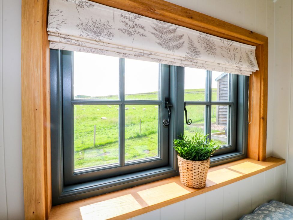 A window with a plant pot on the sill at Pike House Farm Shepherds Hut 2 Thorpe near Ashbourne