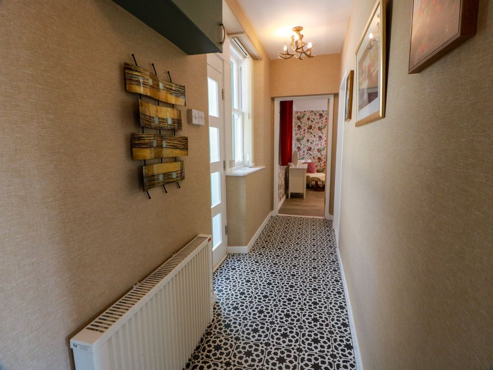 A hallway with a radiator and wall art at Waterside Lodge in Annan