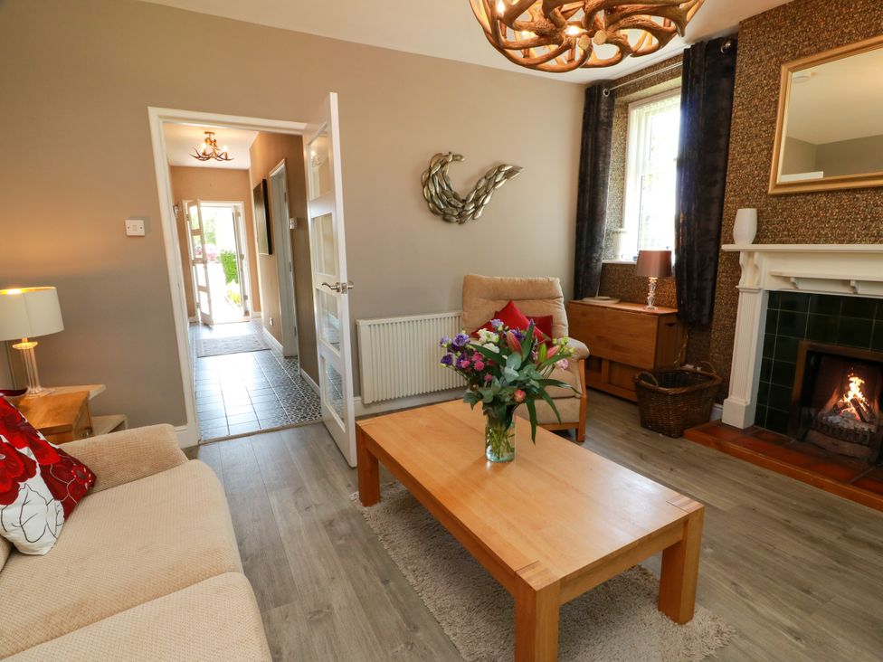 A living room with a coffee table and fireplace at Waterside Lodge in Annan