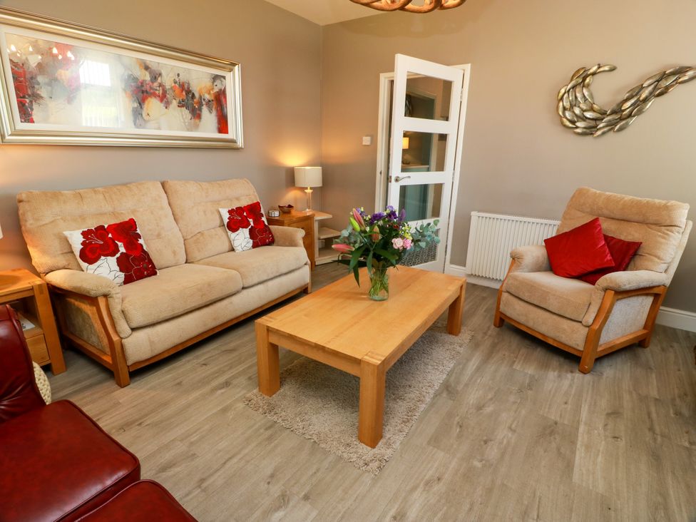 A living room with a sofa and armchair at Waterside Lodge in Annan