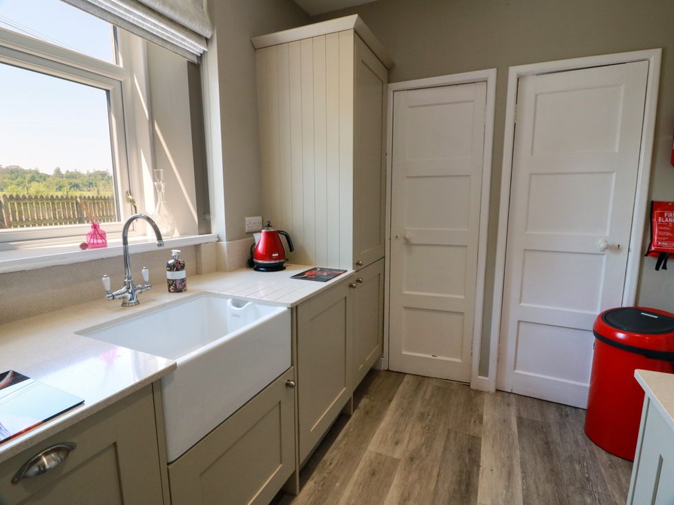 A kitchen with a sink and kettle at Waterside Lodge Annan