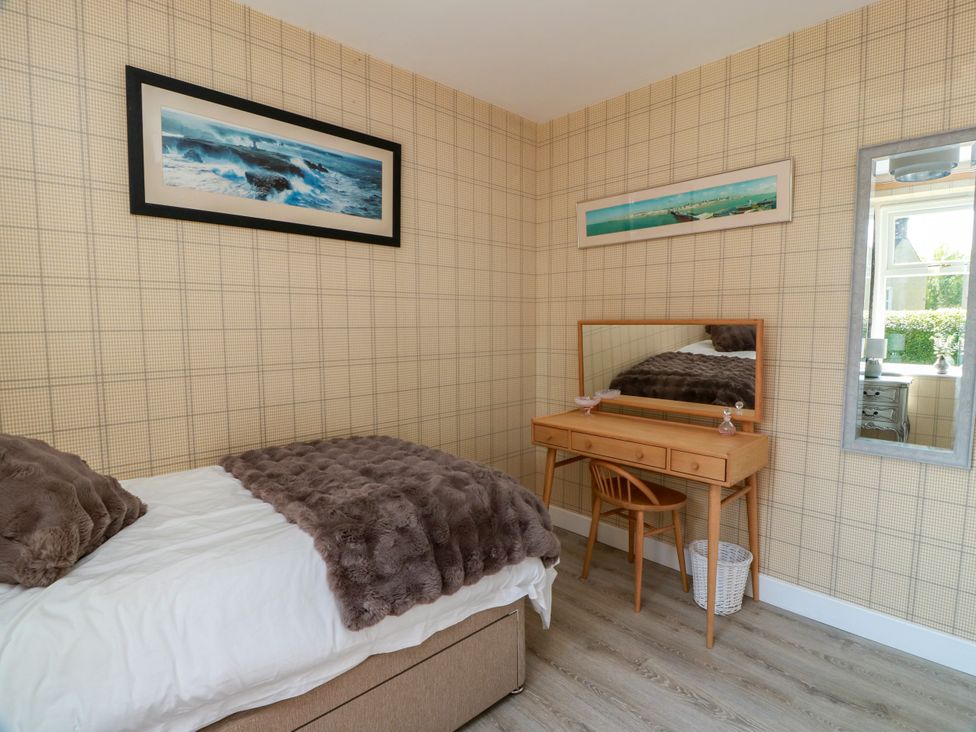 A bedroom with a bed and vanity at Waterside Lodge Annan