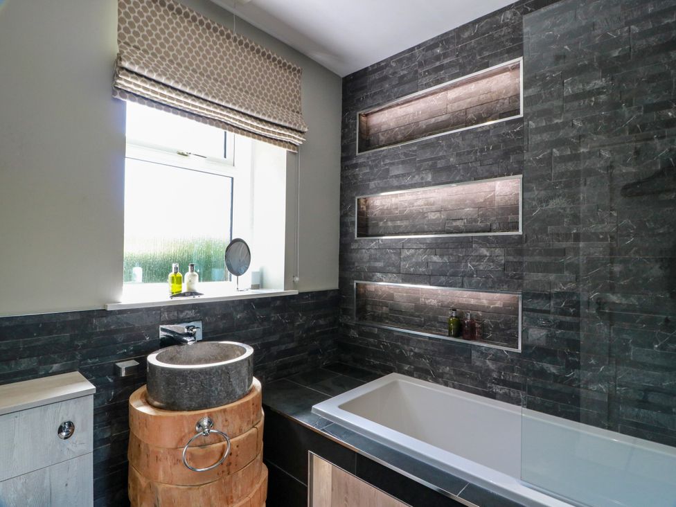 A bathroom with a bathtub and sink at Waterside Lodge in Annan