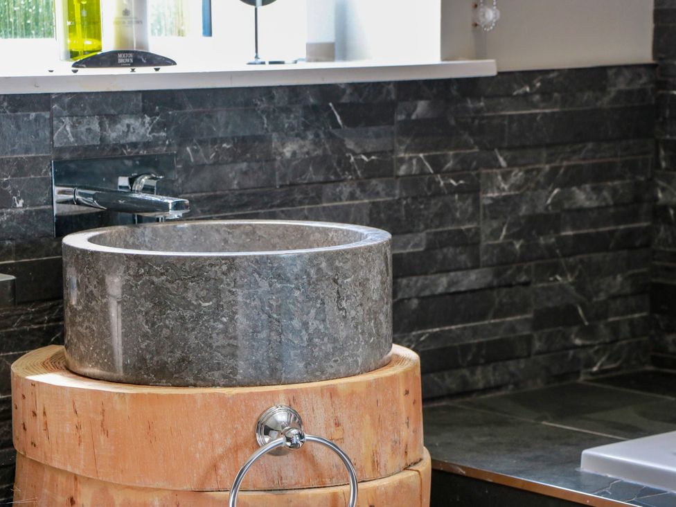 A sink with a marble basin and wooden base at Waterside Lodge in Annan