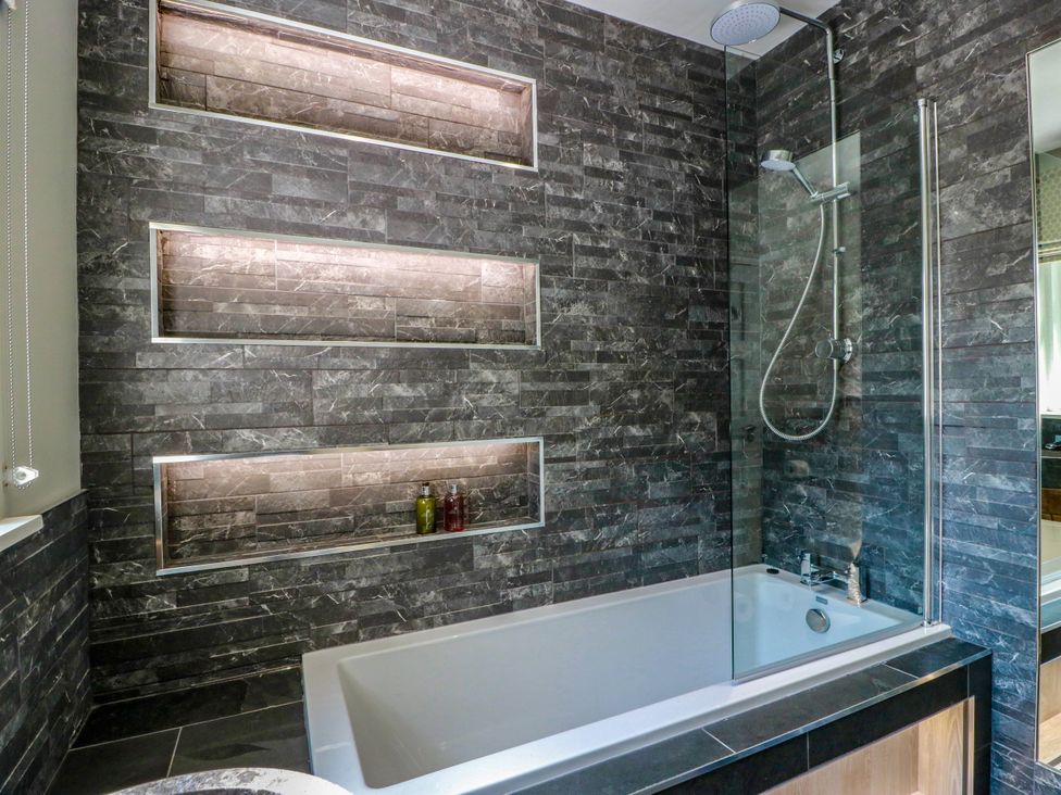 A bathroom with a bathtub and shower at Waterside Lodge in Annan