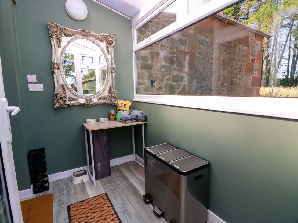 A mudroom with a table and bins at Waterside Lodge in Annan